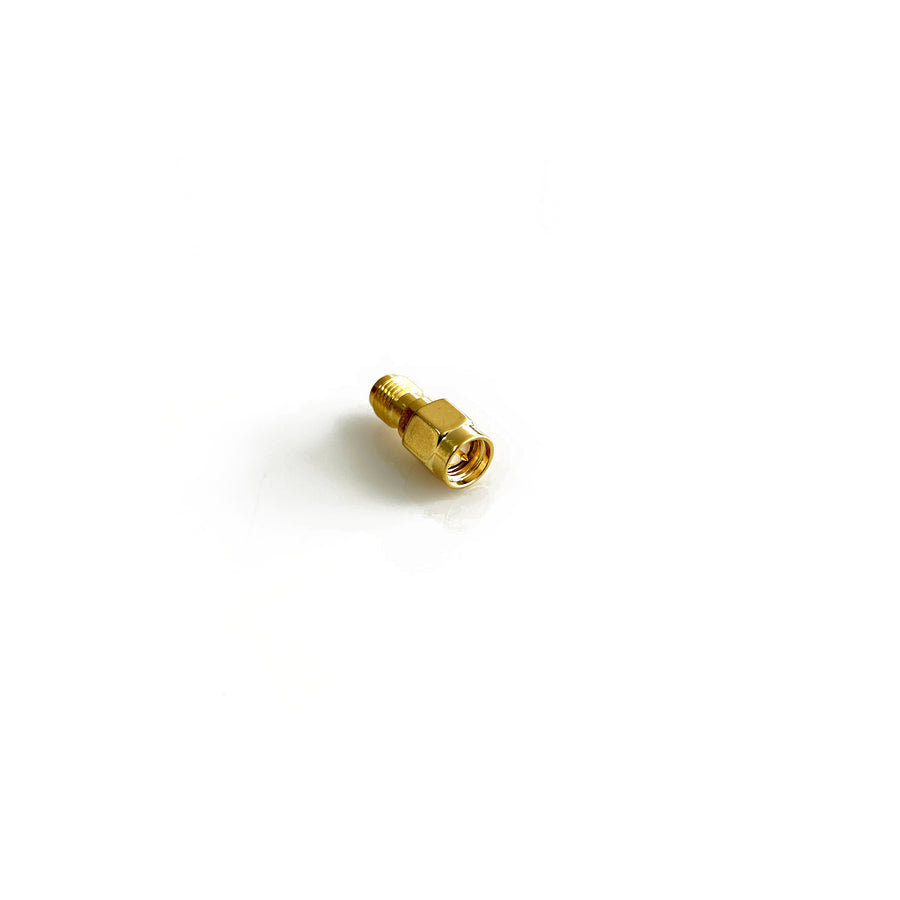An SMA male to female barrel adaptor against a white background